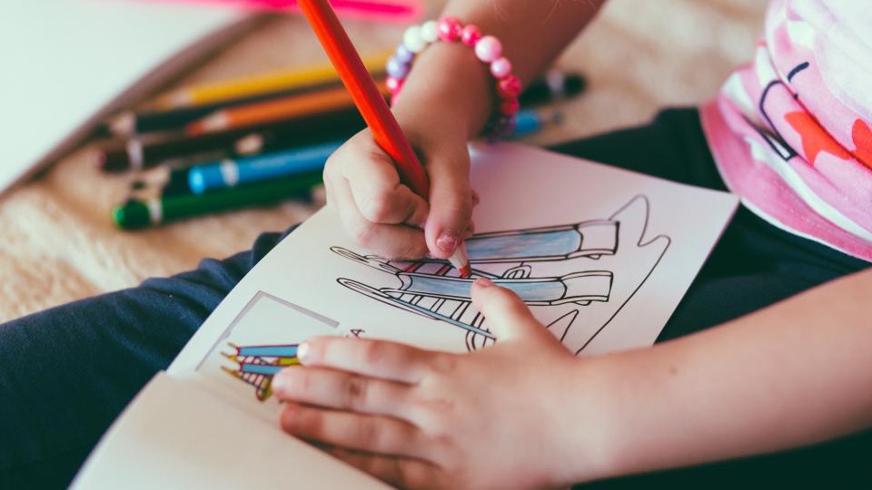 色鉛筆で絵を描く子どもの手元